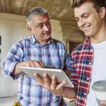 Papà che consiglia dei corsi al figlio guardando sul tablet