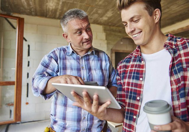 Papà che consiglia dei corsi al figlio guardando sul tablet