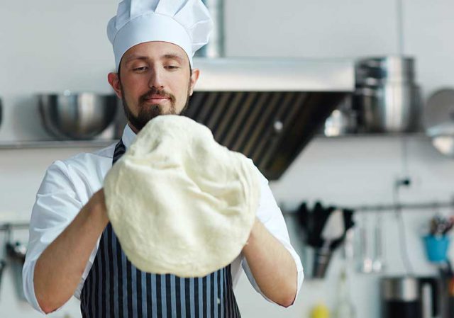 Persona che impara a cucinare impastando pizza o pane