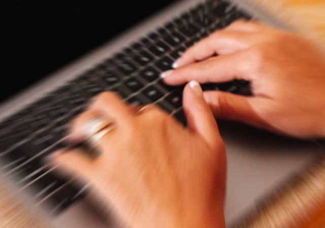 mani femminili che scrivono alla tastiera di un pc